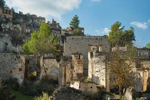 vista da cidade abandonada ao lado de kayakoy. karmilissos cidade fantasma abandonada em fethiye - turquia, ruínas de casas de pedra. local da cidade grega antiga foto