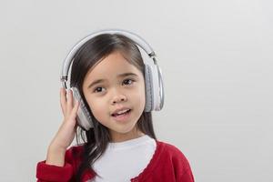 Menina asiática fofa curtindo seus fones de ouvido musicais foto