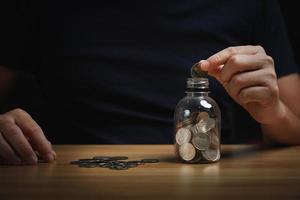 empresário manteve o dinheiro no cofrinho em cima da mesa. conceito de gerenciamento de estabilidade financeira. poupança e pensões, coleta de dinheiro, planejamento financeiro foto