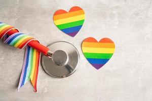 estetoscópio no fundo da bandeira do arco-íris, símbolo do mês do orgulho lgbt comemora anual em junho social, símbolo de gays, lésbicas, bissexuais, transgêneros, direitos humanos e paz. foto
