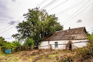 linda e velha casa de fazenda abandonada na zona rural em fundo natural foto