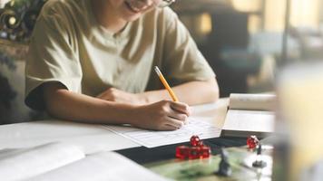 mão de mulher escrevendo para criar história configuração aventura papel jogando mesa e passatempo de jogo de tabuleiro foto