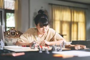 jovem adulta asiática desfrutando de mesa e jogo de tabuleiro foto