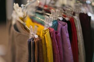 roupas que estão dispostas em prateleiras e cabides foto