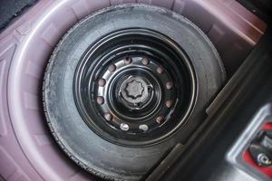 pneu sobressalente no carro compacto moderno foto