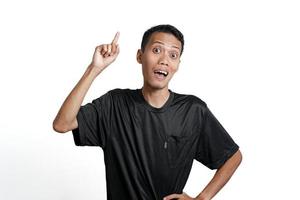 homem asiático vestindo camiseta preta de treinamento, pensando em gestos ou tendo uma ideia. isolado por fundo branco foto
