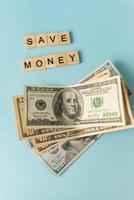 dinheiro em moeda internacional, dólares estão sobre um fundo azul. inscrição economizar dinheiro. foto
