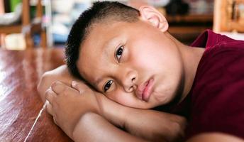 retrato de um menino asiático, cara triste de criança, criança infeliz olhando para fora, emoção triste e rosto triste, conceito de crianças de depressão foto