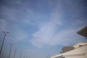 nuvens brancas céu azul com fundo de poste de luz e edifício foto