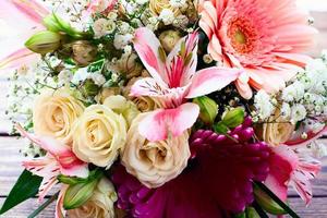 buquê de casamento. flores rosas na superfície de madeira. foto