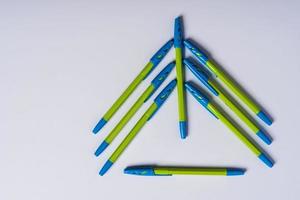 composição minimalista criativa, árvore de natal feita de canetas esferográficas em um fundo branco, artigos de papelaria foto