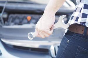 mão de mecânico de automóveis com uma chave de reparo de automóveis. foto