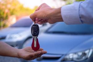 o vendedor de carros e a chave para o novo dono. foto