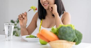 belas mulheres asiáticas estão gostando de comer salada para perder peso. jovem saudável comendo salada de legumes. dieta, conceitos de comida saudável.