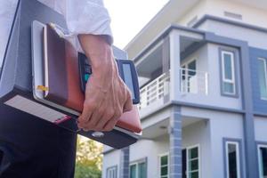 close-up da mão do jovem segurando equipamentos e documentos de trabalho voltam para fazer em casa. trabalhar em casa conceito foto