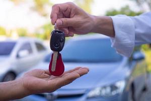 agências de vendas estão vendendo carros e dando as chaves para novos proprietários. vender carro ou carro alugado foto