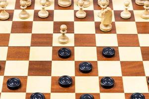 início do xadrez - jogo de damas no tabuleiro de madeira foto