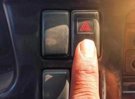 pressione com o dedo o botão da luz de emergência com o símbolo do triângulo vermelho.