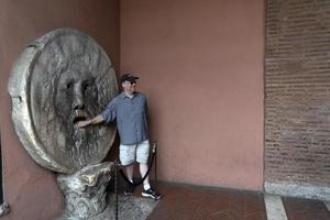 Roma, Itália - 15 de junho de 2019 - turista testando a boca da máscara da verdade foto