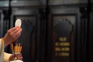 padre mostrando a hóstia durante a missa foto