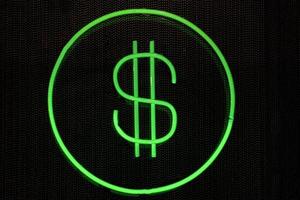 símbolo do dólar verde neon brilhante isolado em preto foto