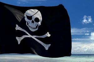 acenando a bandeira de pirata jolly roger no fundo da ilha tropical foto