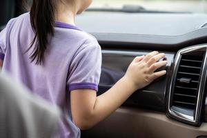 menina asiática de 3 a 5 anos está olhando para fora pelo espelho da janela do carro. foto