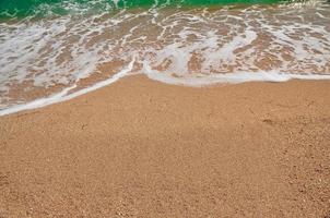 onda do mar correu para a praia de areia. viagens de verão foto