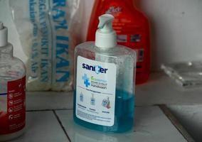jacarta, indonésia - 27 de janeiro de 2023 - saniter ecosense azul sabão para as mãos lavar bomba de garrafa de plástico transparente na mesa de cerâmica, com decorações de objetos aleatórios ao redor. foto