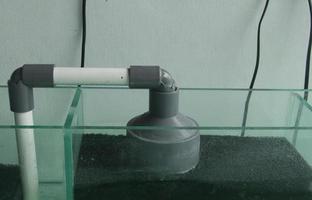 feche a foto isolada do tubo de bomba de tanque de vidro de aquário doméstico no modelo de retângulo