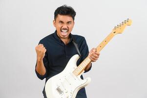 retrato de jovem asiático na camisa azul com guitarra eletrônica isolada no fundo branco foto