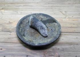 tigela de purê de cozinha ou conhecida como cobek ou cowek na indonésia feita de pedra para purê de ervas ou especiarias. argamassa de pedra. foto