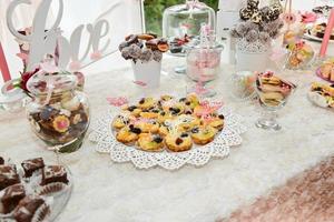 doces e biscoitos dispostos na mesa para festa de casamento foto