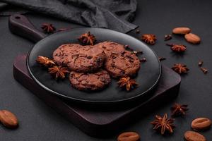 deliciosos biscoitos de chocolate com nozes em uma placa de cerâmica preta foto