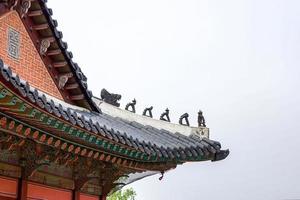 o telhado do palácio histórico da coreia foi decorado com uma pequena estátua. foto