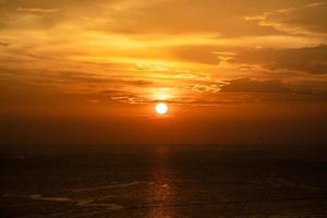 pôr do sol no mar e através das nuvens. paisagem marítima tranquila com o horizonte horizontal. foto