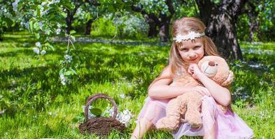 menina adorável no jardim de macieiras em flor em maio foto