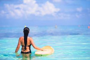 linda surfista surfando durante as férias de verão foto