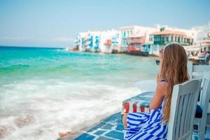 menina adorável na pequena veneza a área turística mais popular da ilha de mykonos, grécia. foto