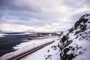 estrada para o porto entre as rochas e a neve com o porto de nuuk ao fundo, gronelândia foto