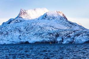 enorme sermitsiaq montanha coberta de neve com mar azul e pequeno barco fidhing em primeiro plano, nas proximidades da cidade de nuuk, Groenlândia foto