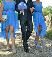 casamento tradicional romeno. noivo junto com as damas de honra estão caminhando pelas estradas da vila foto