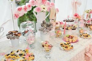 doces e biscoitos dispostos na mesa para festa de casamento foto