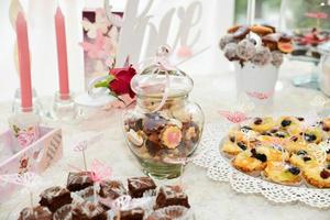 doces e biscoitos dispostos na mesa para festa de casamento foto