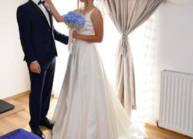 noiva e noivo juntos segurando um buquê de flores azuis foto