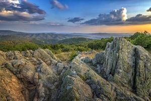 rochas incríveis na beira de uma montanha. bela paisagem de verão das montanhas ao pôr do sol foto