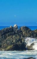 belas rochas falésias surfista ondas na praia puerto escondido méxico. foto