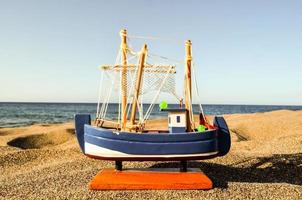 modelo de barco pequeno na areia foto