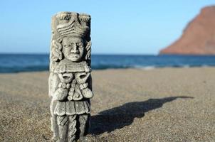 pequena estátua na praia foto