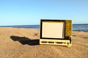 televisão velha na areia foto